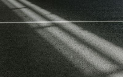 Abstract view of light and shadow on a textured floor.